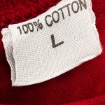 a t-shirt tag with 100% cotton writen on it